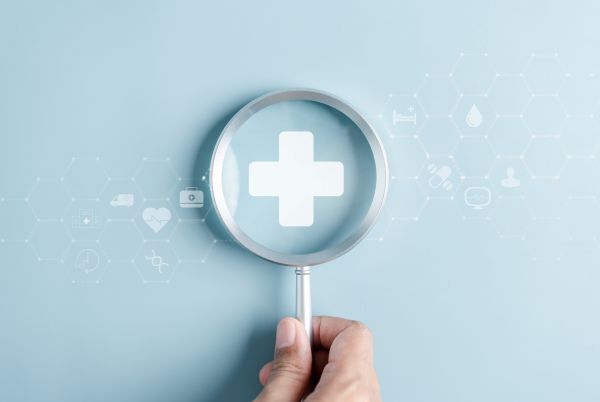 Magnifying glass with medical symbol, preventative kidney care, kidney disease exam and symptoms