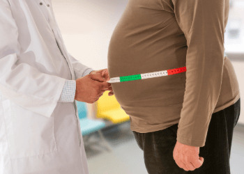 Doctor measuring obese man waist