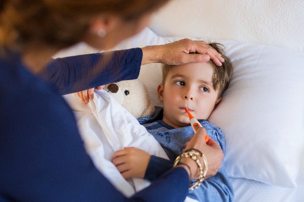 Parent-checking-temp-of-child-with-cold