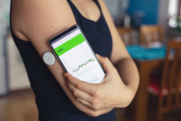 Woman-checking-diabetes-blood-glucose-levels-with-phone