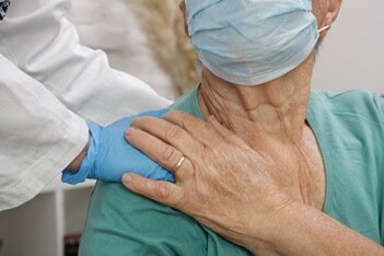 older female patient wearing mask being comforted by doctor | Caldwell Urgent Care 