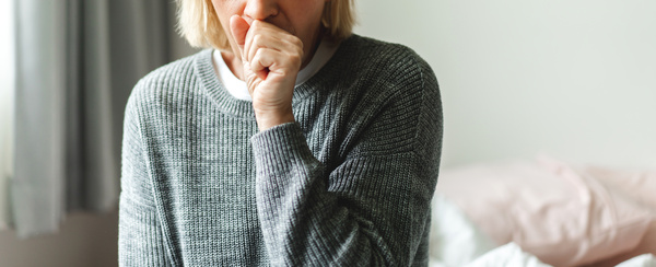 A woman sneezing, seasonal allergies, COVID-19, coronavirus symptoms, Caldwell urgent care